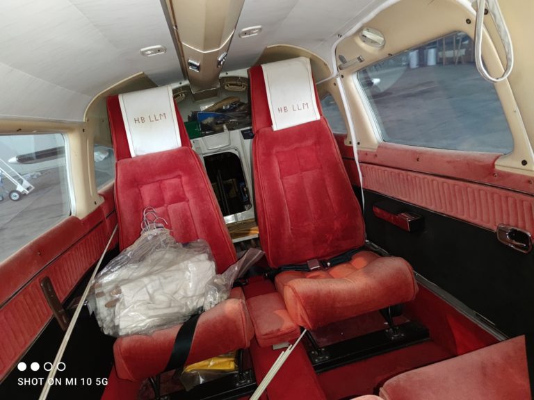 Interior of small aircraft with red seats.