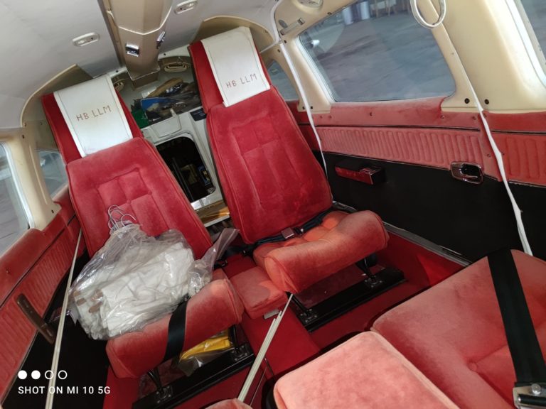 Interior of red-upholstered light aircraft cockpit.