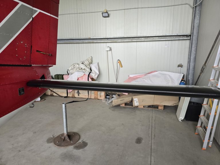 Airplane tail and storage items in hangar.