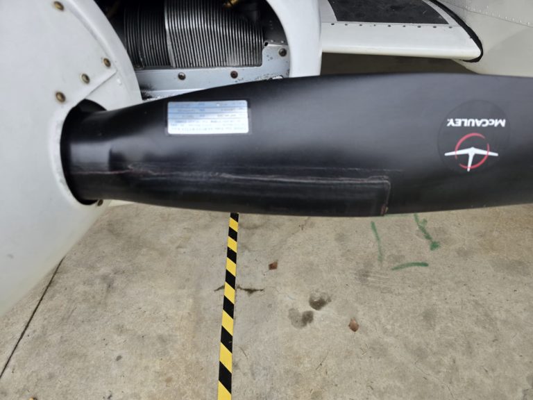 Close-up of airplane propeller blade on tarmac.