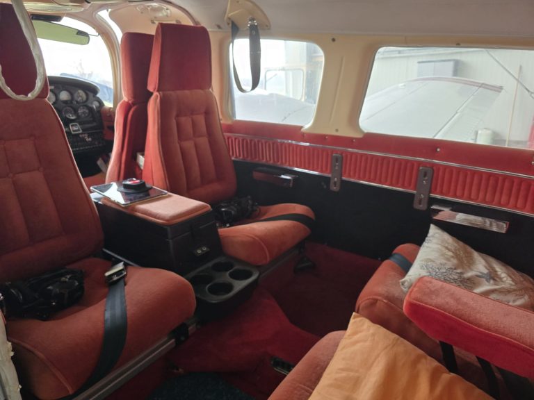 Vintage airplane interior with red fabric seats.