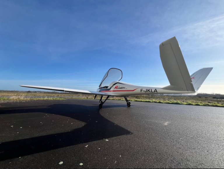 Small aircraft on airstrip under clear sky