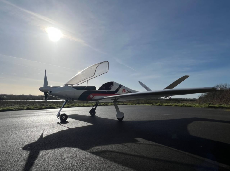 Light aircraft on runway under bright sun