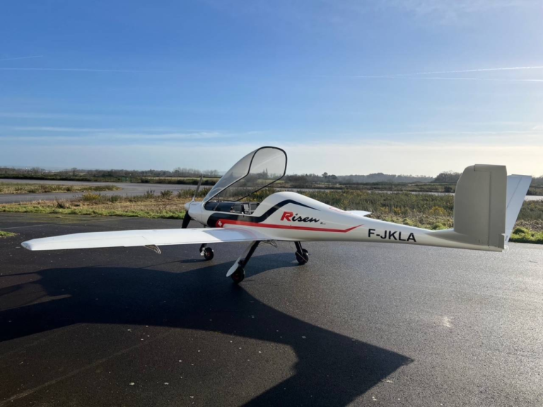 Modern single-engine aircraft on runway with clear sky.