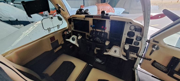 Small aircraft cockpit with controls and displays.