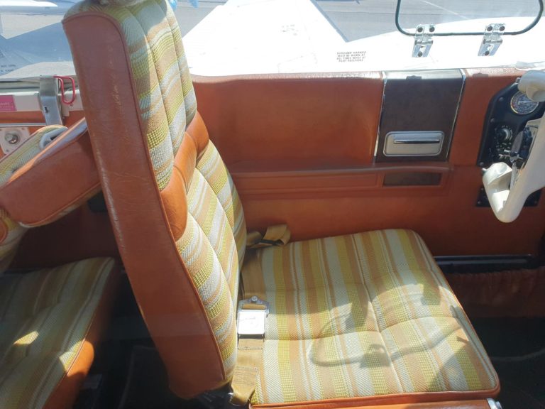 Airplane cockpit seat with striped upholstery.
