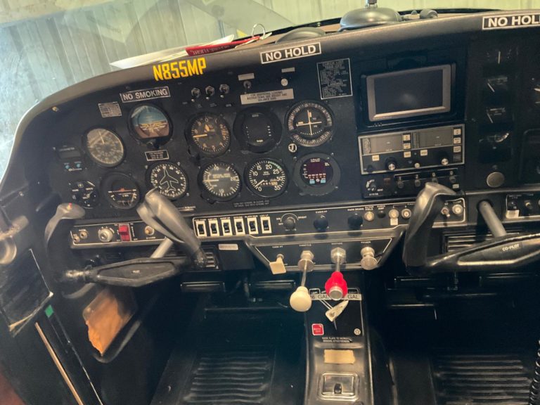 Airplane cockpit with control instruments and steering yokes.
