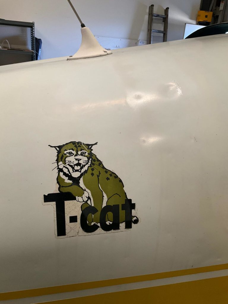 Airplane side featuring a T-cat logo design.