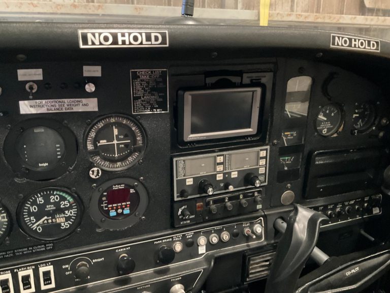 Aircraft cockpit with instrument panel and controls.