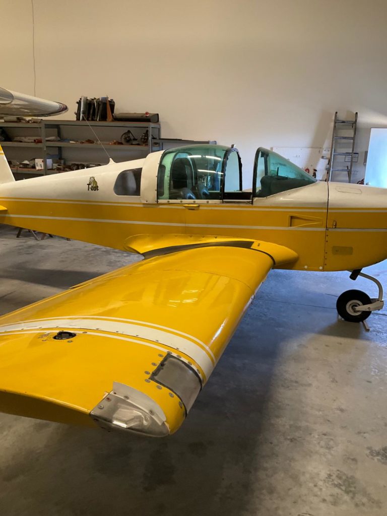 Yellow small aircraft in a hangar