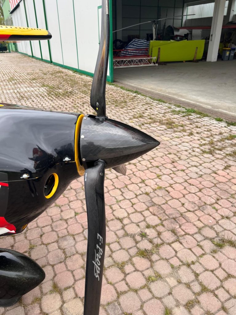 Airplane propeller with yellow accents in hangar entrance.