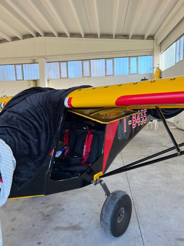 Yellow and black small aircraft in hangar