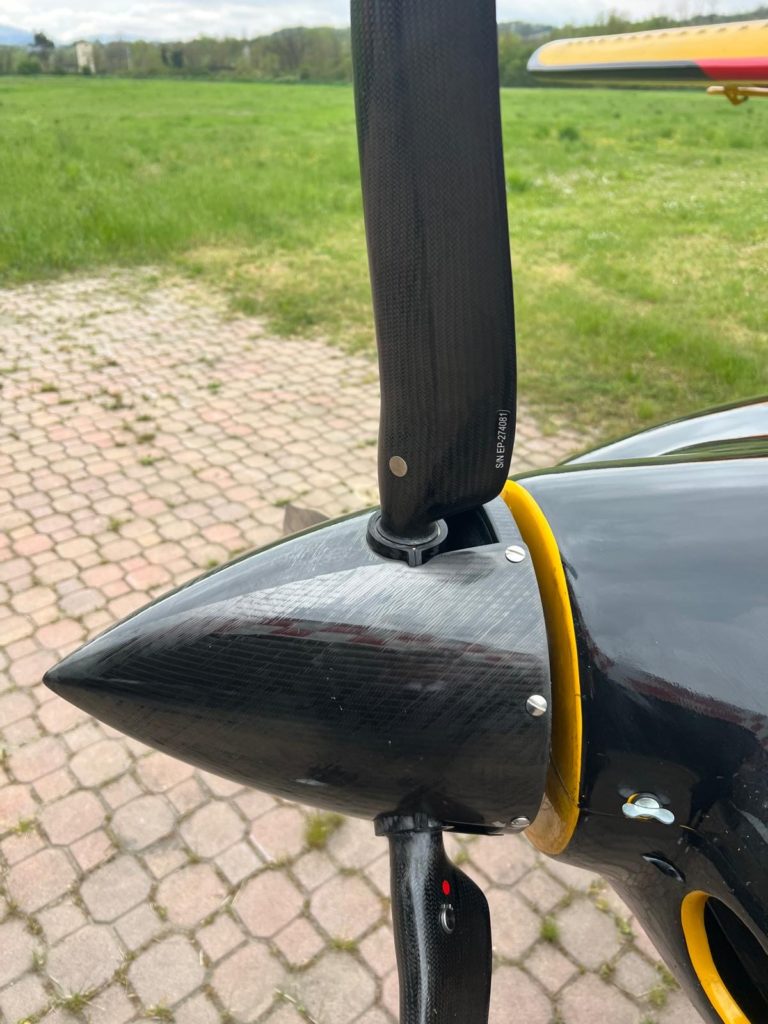 Close-up of a black aircraft propeller on ground.