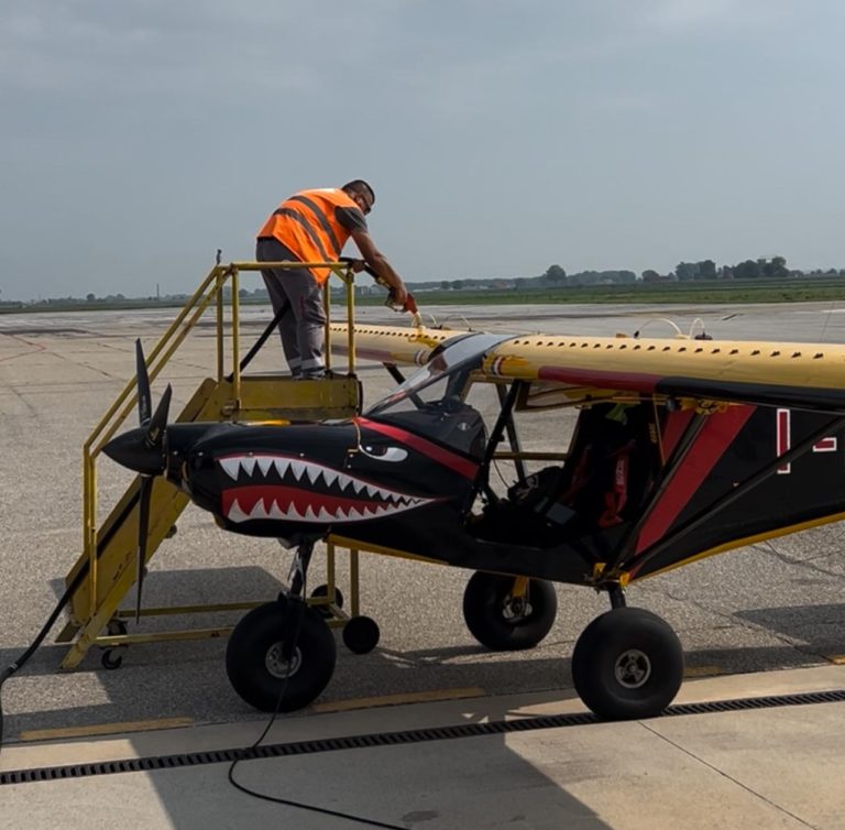 Worker refuels airplane with shark mouth design