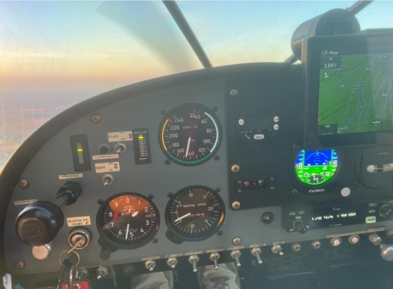 Aircraft cockpit with instruments and navigation screen.