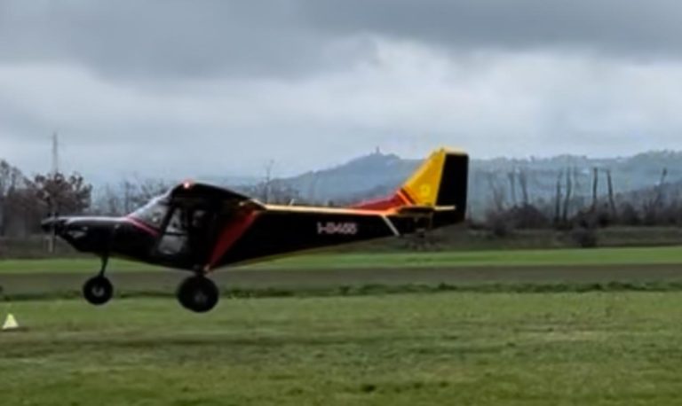 Small aircraft landing on grassy field