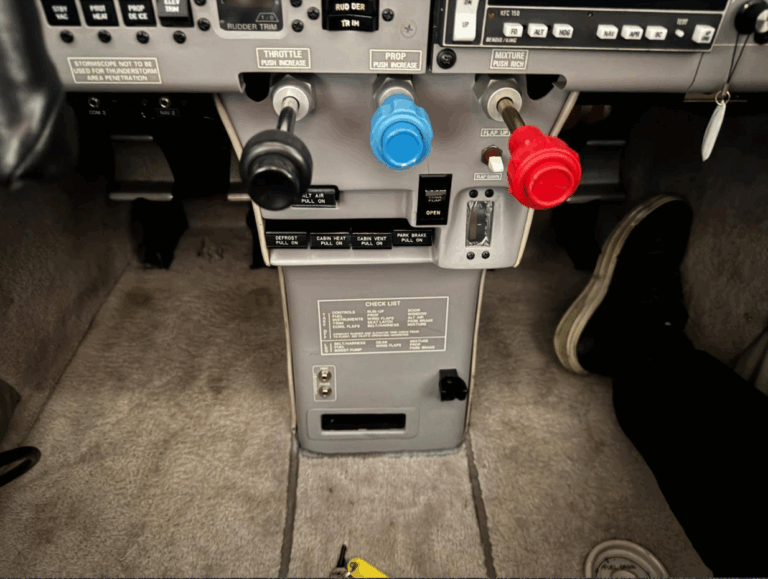 Airplane cockpit controls with throttle and mixture levers.