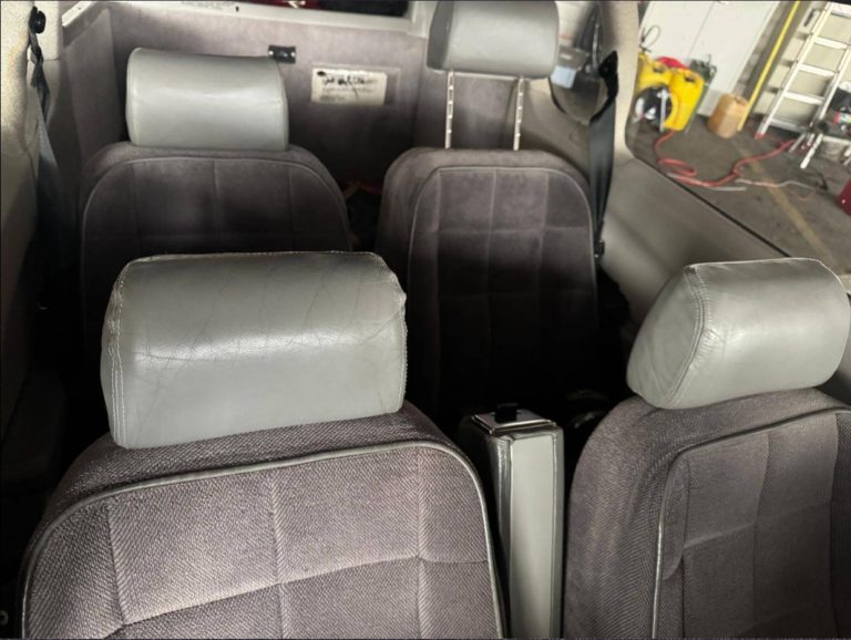 Gray car interior with four seats and headrests.