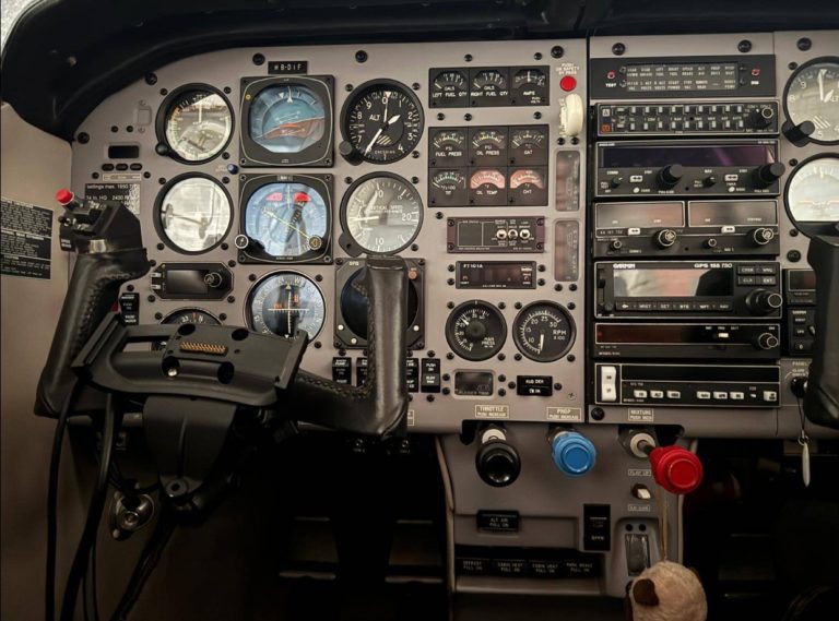 Aircraft cockpit dashboard with various controls and gauges.