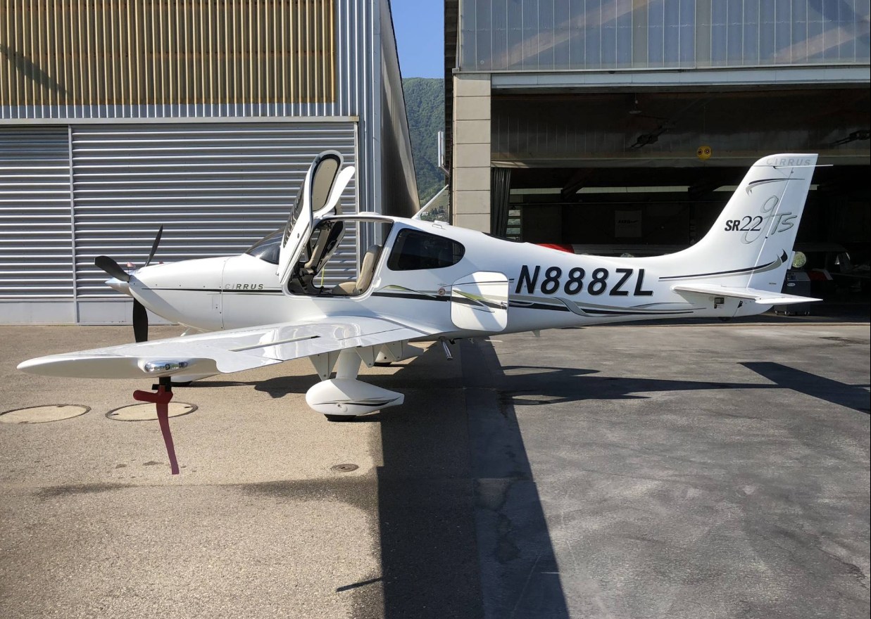 White airplane parked outside a hangar
