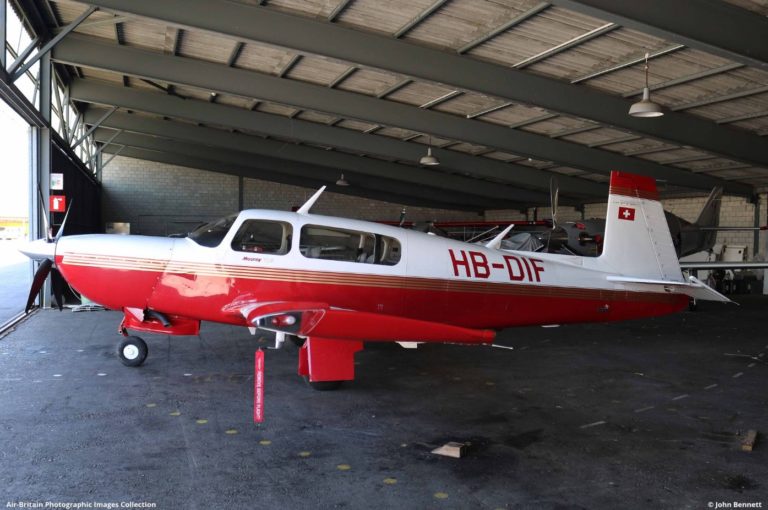Red and white airplane in hangar