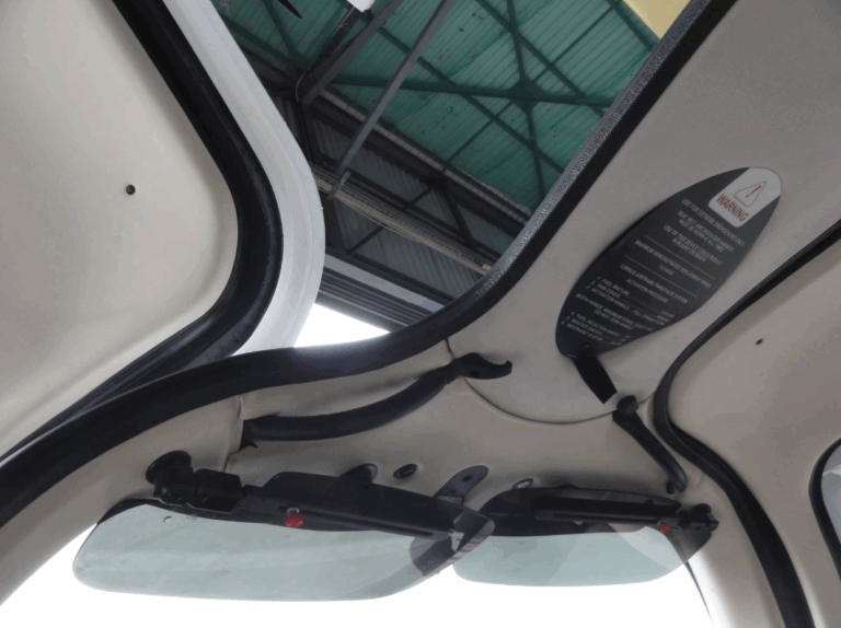 Open car sunroof with warning sign visible.