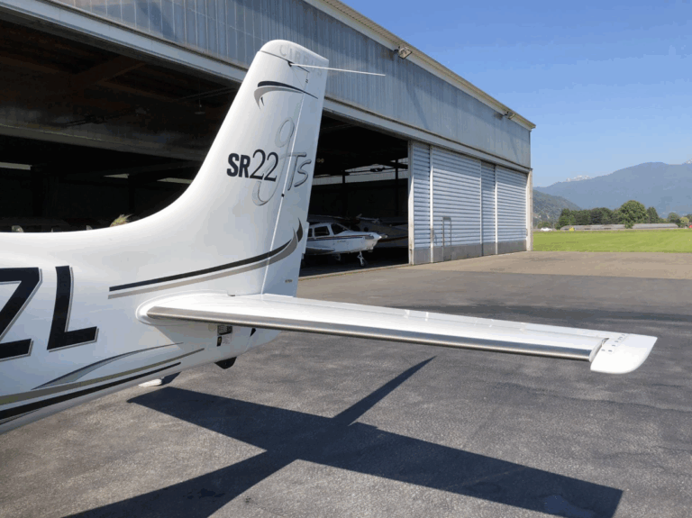 Tail of Cirrus SR22T aircraft near hangar