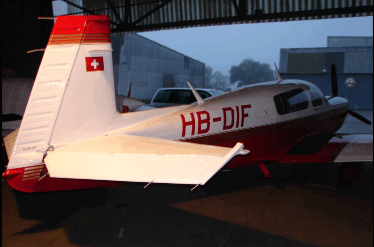 Red and white aircraft in a hangar
