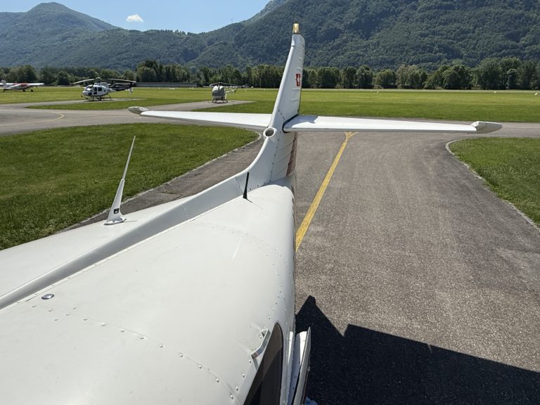 Airplane taxiing on runway, helicopters parked nearby.