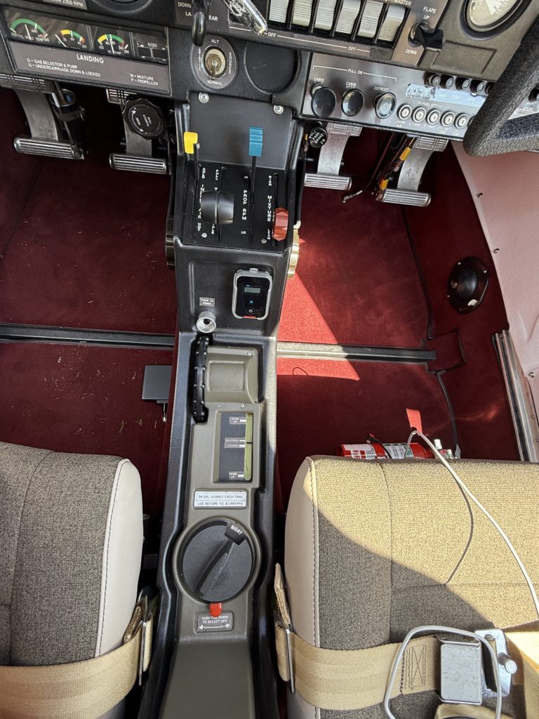 Small aircraft cockpit control panel with red floor mat