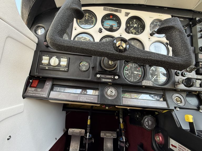 Airplane cockpit with flight instruments and controls.