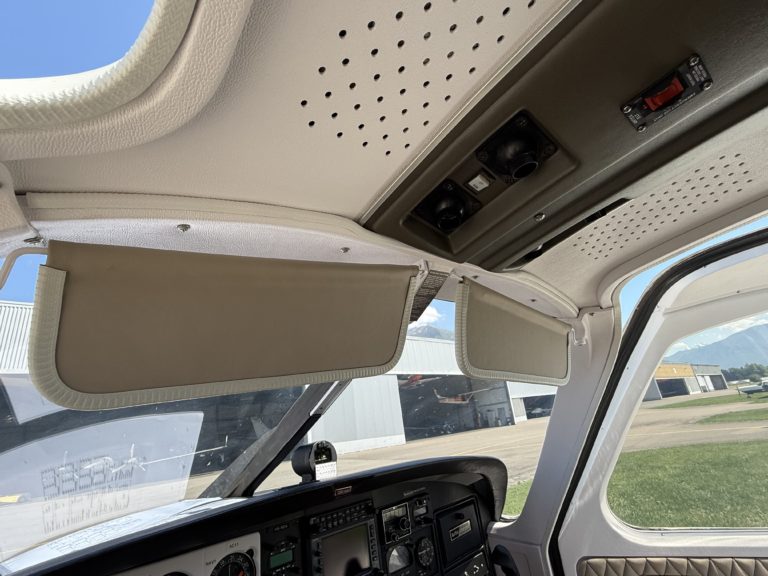 Airplane interior with sun visors and controls.