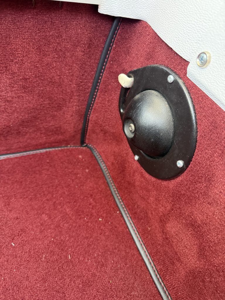 Vintage car interior with red carpet and knob