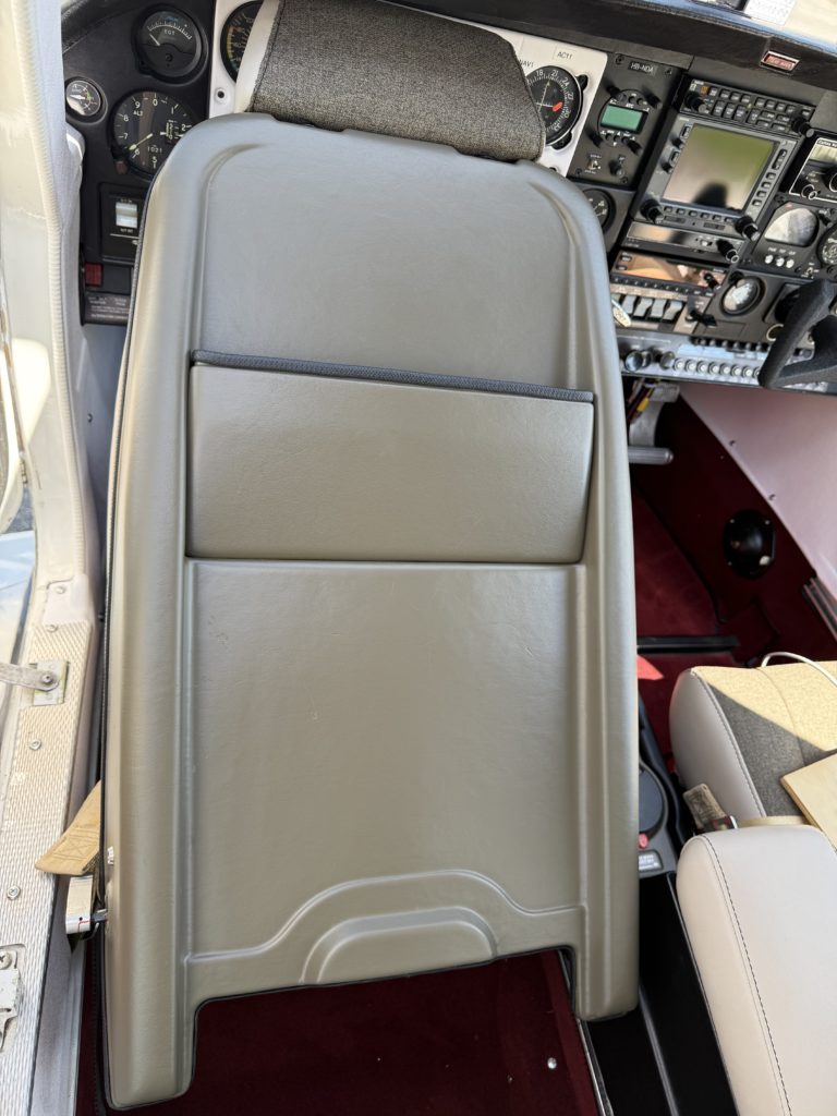 Cockpit interior with control panel and seat back.