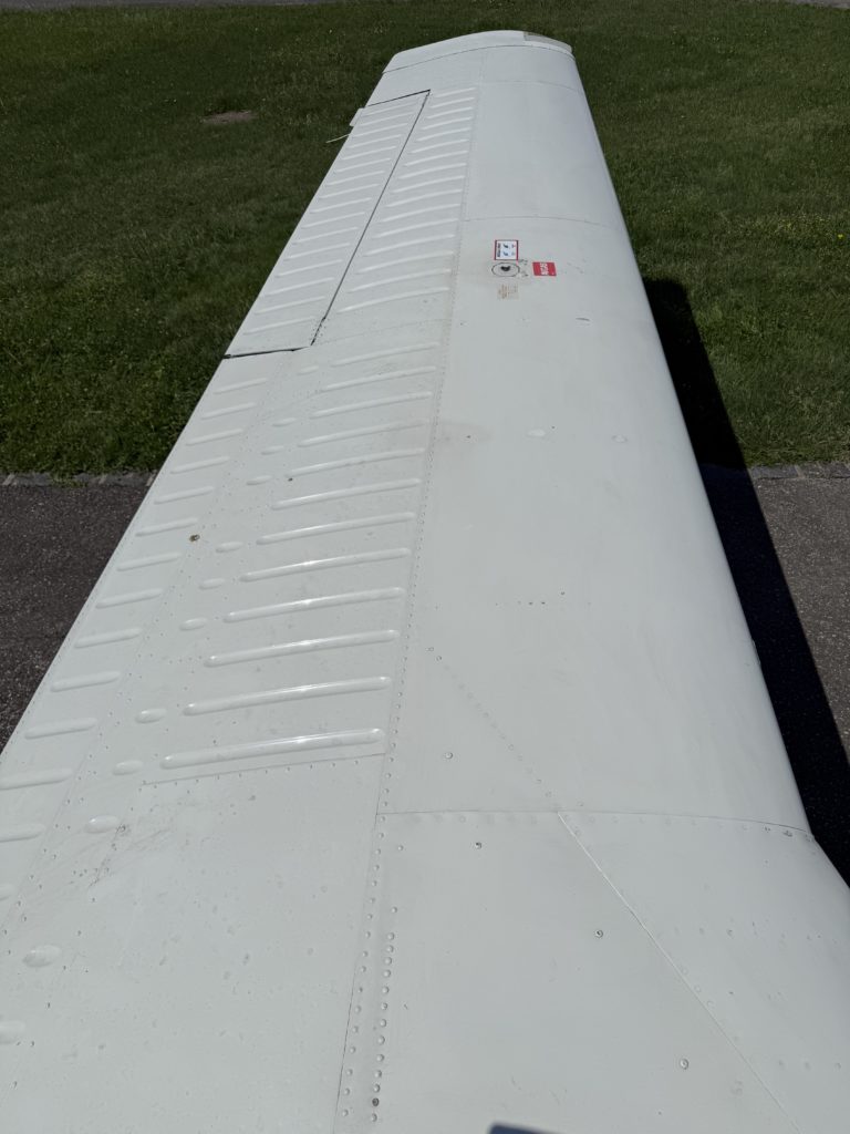 Airplane wing on grassy airfield