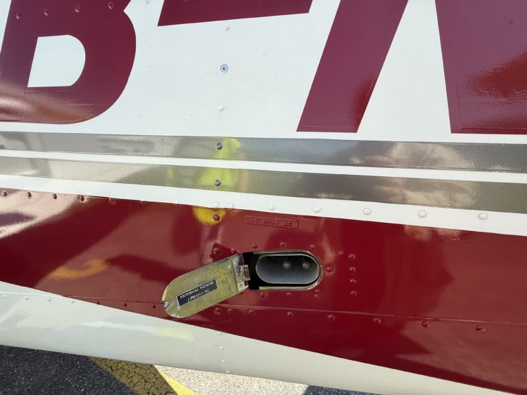 Airplane external power port with cover open.
