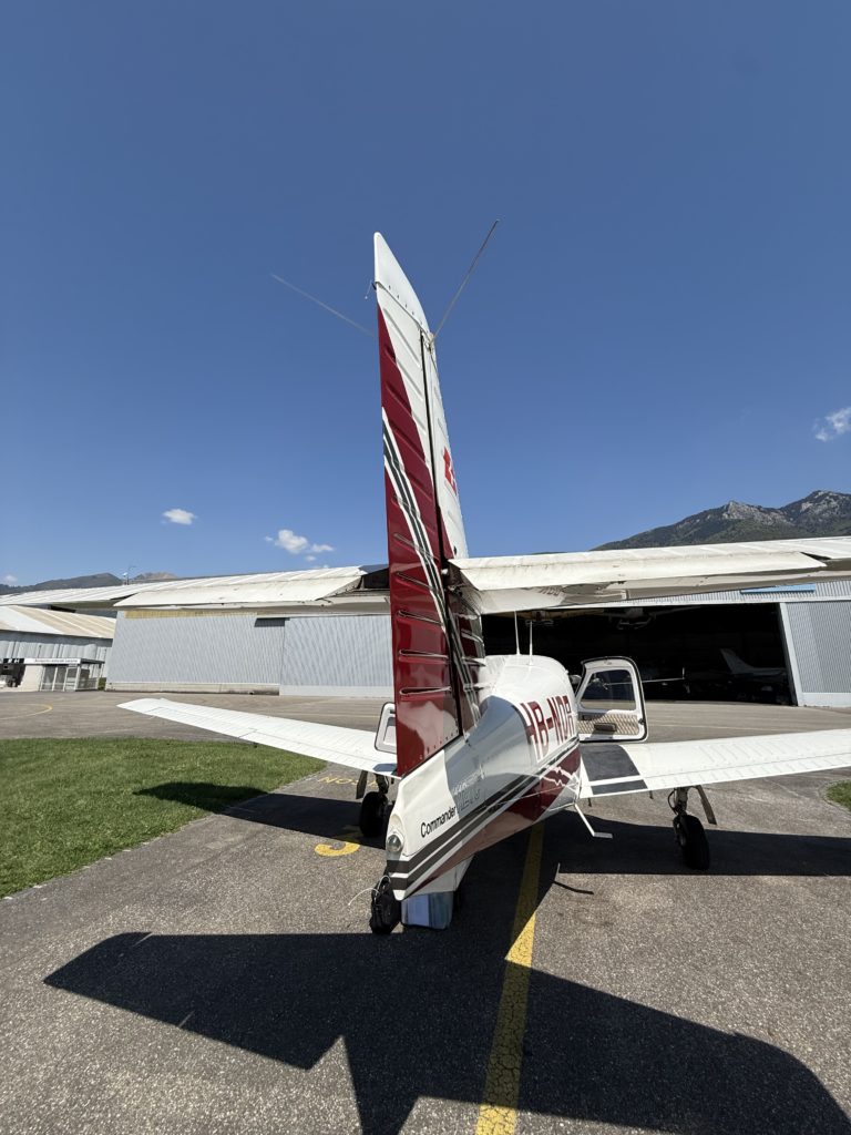 Small aircraft parked near hangar on sunny day.