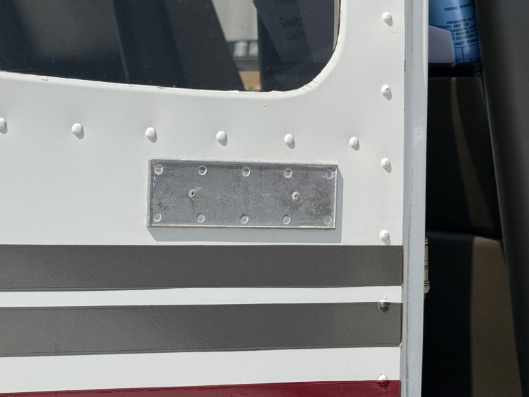 Close-up of small metallic aircraft door detail.