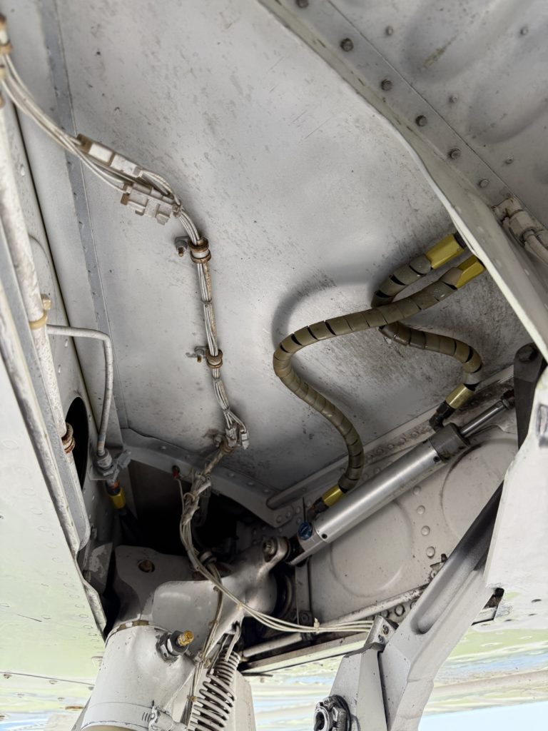 Aircraft landing gear compartment with hydraulic components.