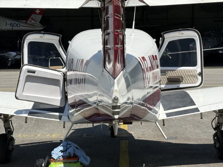 Small airplane with open doors on runway.