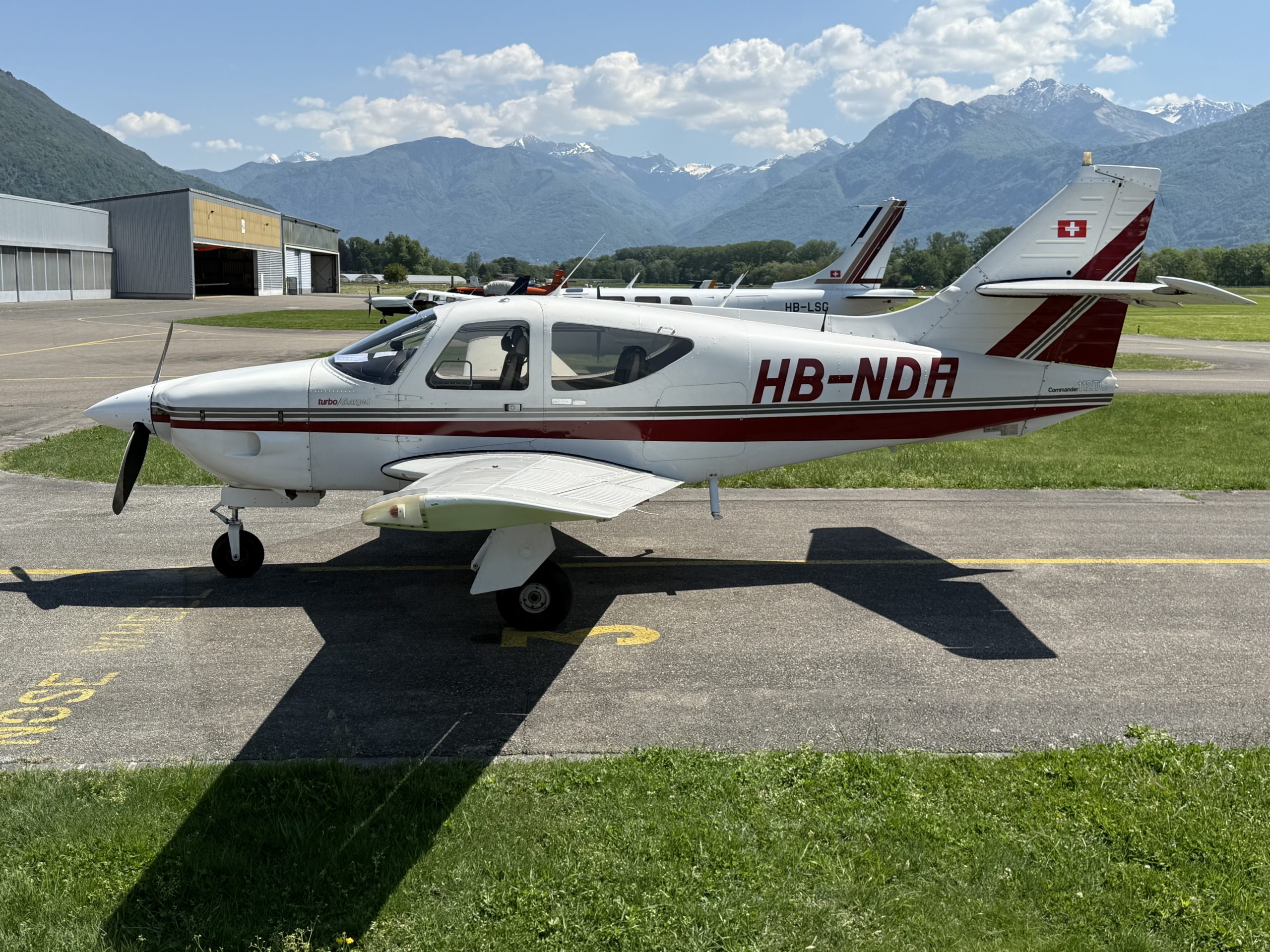 Small airplane parked on mountain airstrip.
