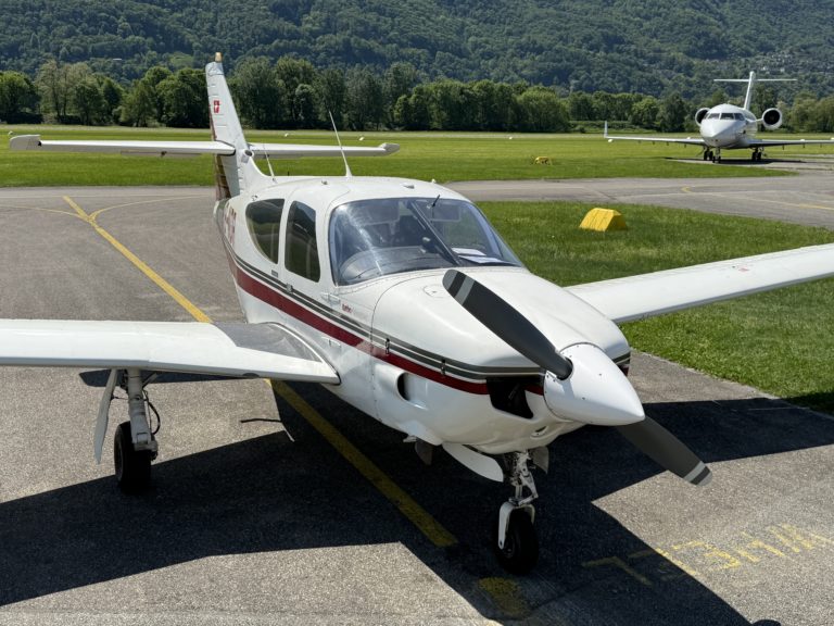 Small propeller plane on runway with hills background.