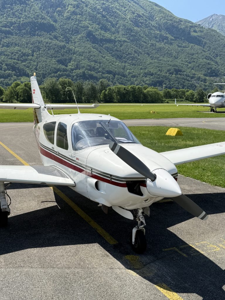 Small airplane parked with mountain view.