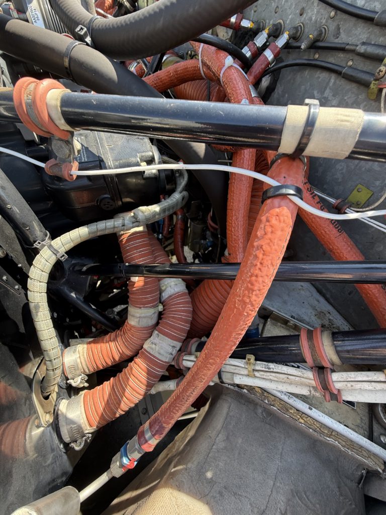 Close-up of complex engine hoses and wires.