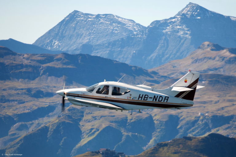 Small airplane flying over mountains