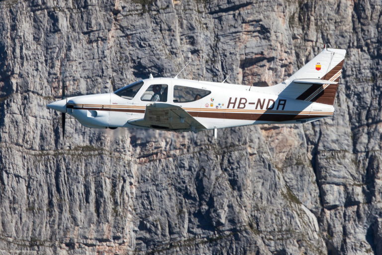 Small airplane flying near rocky cliffs