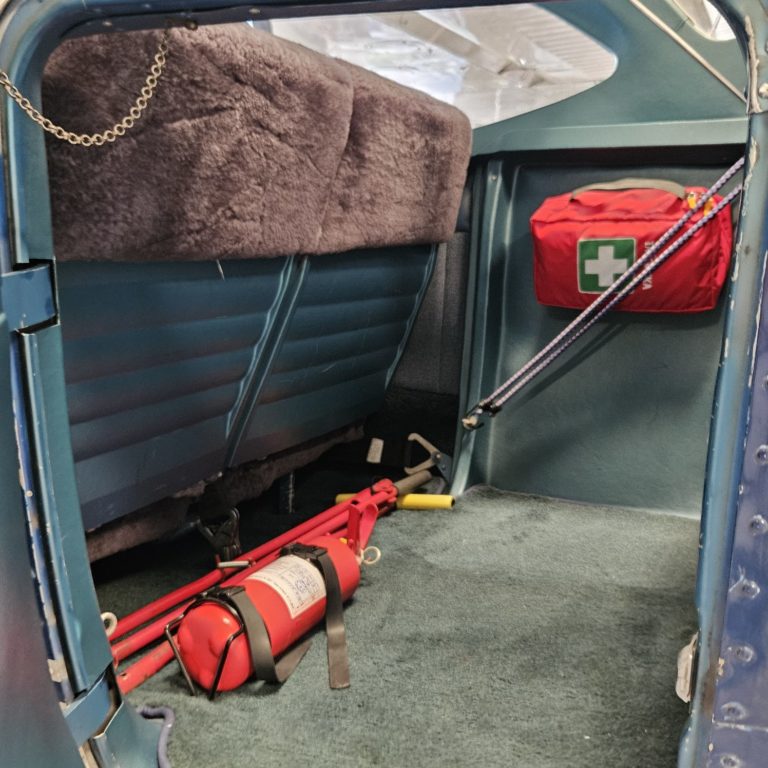 Airplane interior with fire extinguisher and first aid kit.