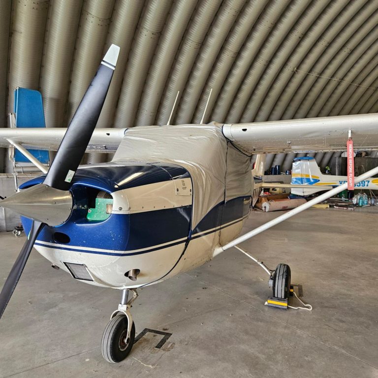 Small airplane parked inside a hangar.