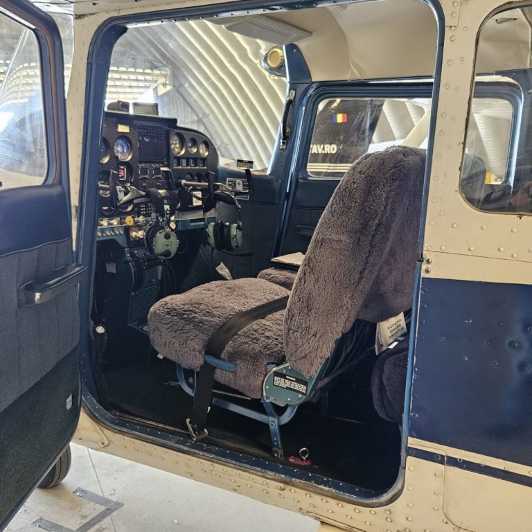 Small aircraft cockpit interior with controls and seats.