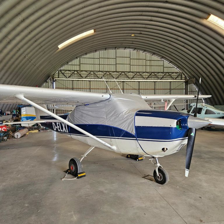 Small airplane parked inside a hangar.